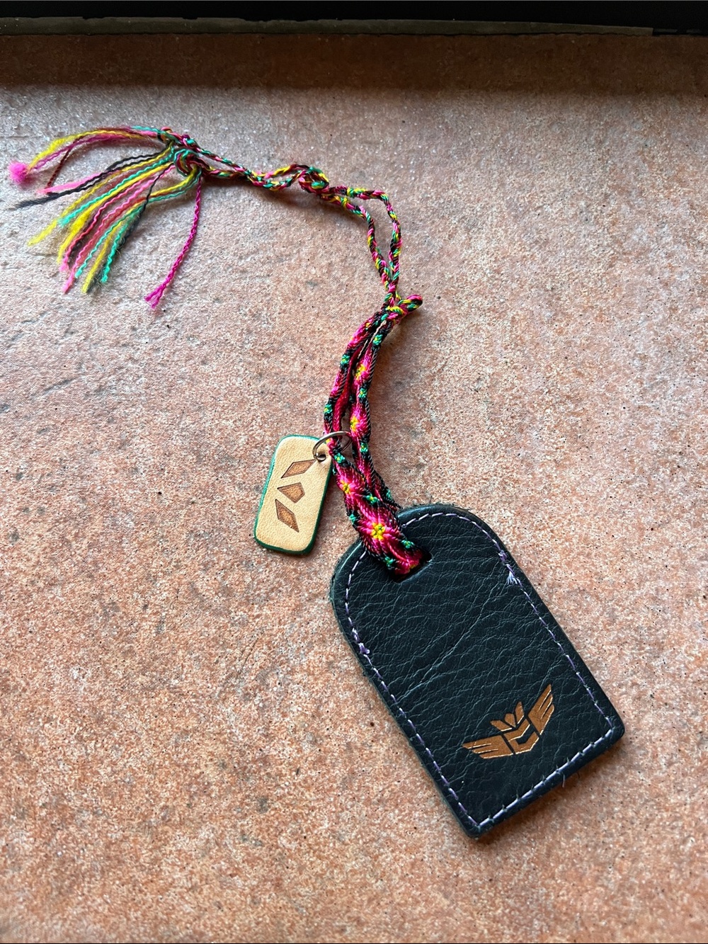 CONSUELA BLACK LEATHER BAG TAG WITH BRAIDED BRACELET AND CHARM